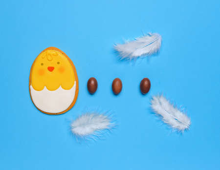 Tasty chocolate eggs and Easter cookie on color backgroundの写真素材