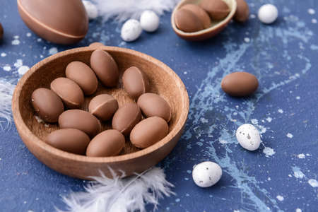 Plate with tasty chocolate eggs on color backgroundの写真素材