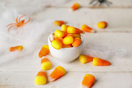 Bowl with tasty candy corns for Halloween on table