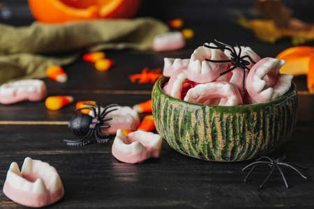 Bowl with tasty treats for Halloween on table