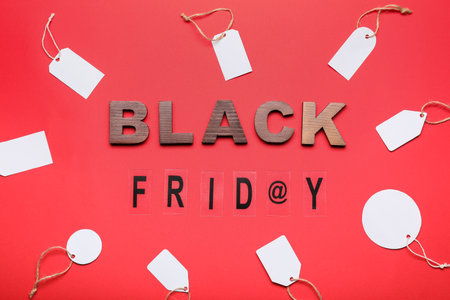 Text BLACK FRIDAY with shopping tags on color background