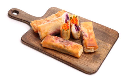 Board with tasty fried spring rolls on white background