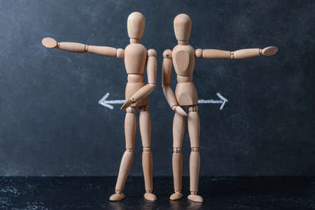 Wooden mannequins with arrows on dark backgroundの写真素材