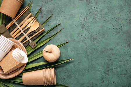Eco tableware and wooden apple on color background