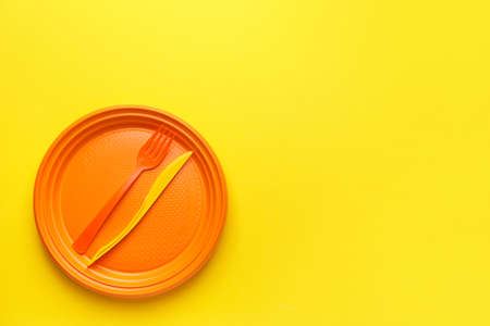 Plastic tableware on color background