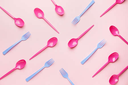 Plastic spoons and forks on color backgroundの写真素材
