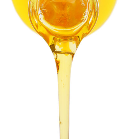 Pouring of fresh olive oil from bottle on white backgroundの写真素材