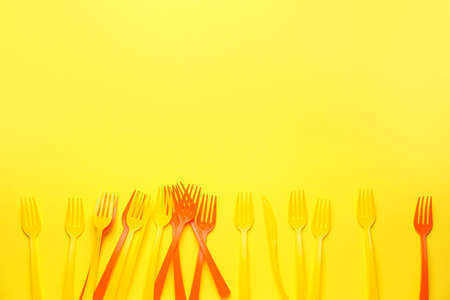 Plastic forks on color background