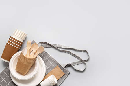 Eco tableware and bag on light background