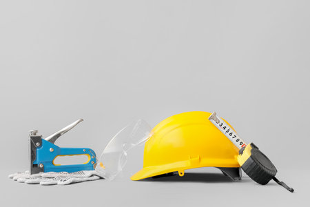 Hardhat and construction tools on gray background