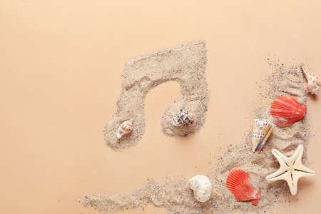 Music note made of sea sand and shells on color backgroundの写真素材