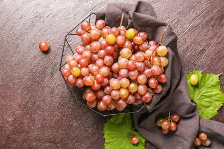 Sweet ripe grapes in bowl on tableの写真素材