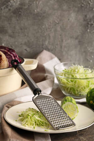 Plate with zucchini and grater on grunge backgroundの写真素材
