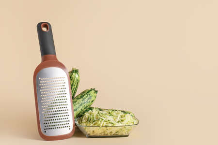 Metal grater and zucchini on color backgroundの写真素材