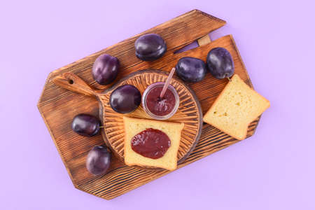 Composition with delicious homemade plum jam on color background