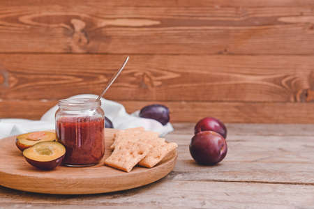 Composition with delicious homemade plum jam on wooden backgroundの写真素材