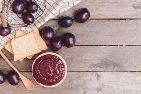 Bowl with delicious homemade plum jam on wooden backgroundの写真素材