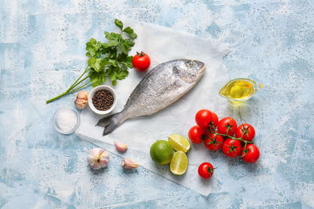 Raw dorado fish with ingredients on color backgroundの写真素材