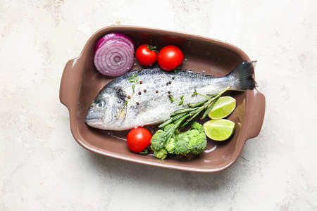 Raw dorado fish with vegetables on light backgroundの写真素材