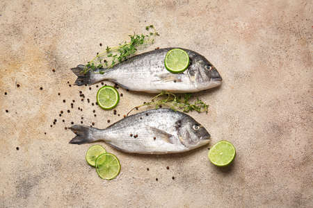 Raw dorado fish with lime and spices on grunge backgroundの写真素材