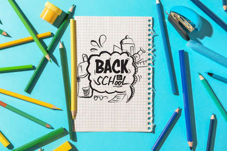 Set of stationery and paper sheet with text BACK TO SCHOOL on color backgroundの写真素材