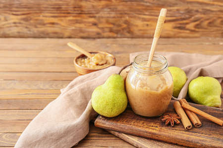 Jar of tasty pear jam on wooden backgroundの写真素材