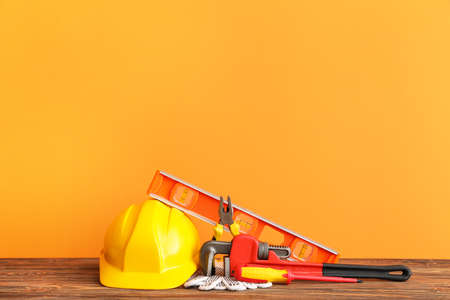 Set of construction tools on wooden table against color backgroundの写真素材
