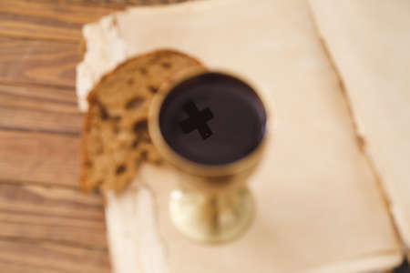 Reflection of cross in chalice of wine on tableの写真素材