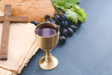 Chalice of wine, Holy Bible and cross on dark backgroundの写真素材