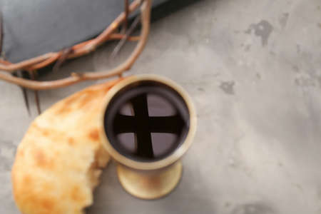 Reflection of cross in chalice of wine on tableの写真素材
