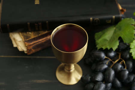 Chalice of wine with Holy Bible on dark wooden backgroundの写真素材