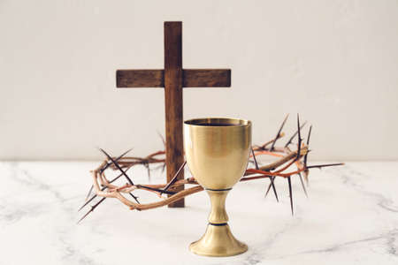 Chalice of wine, cross and crown of thorns on white backgroundの写真素材