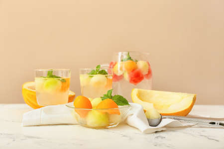 Tasty melon balls with cold cocktail on tableの写真素材