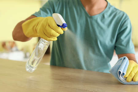 Young man cleaning his kitchen, closeup