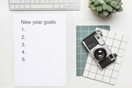 Empty to do list on new year with photo camera and computer on white backgroundの写真素材