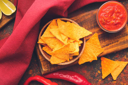 Board with tasty nachos and sauce on grunge backgroundの写真素材