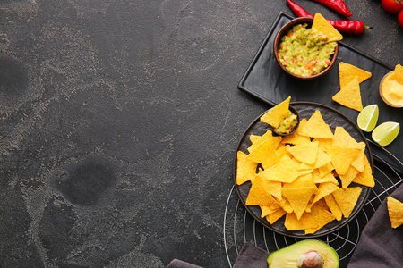 Plate with tasty nachos and sauces on dark backgroundの写真素材