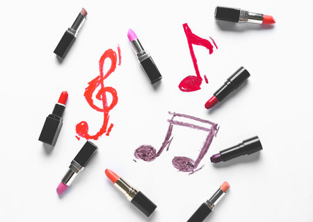 Drawn music notes and makeup cosmetics on white backgroundの写真素材