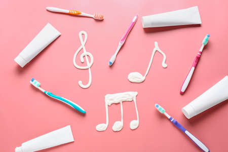 Drawn music notes and tooth brushes with paste on color backgroundの写真素材