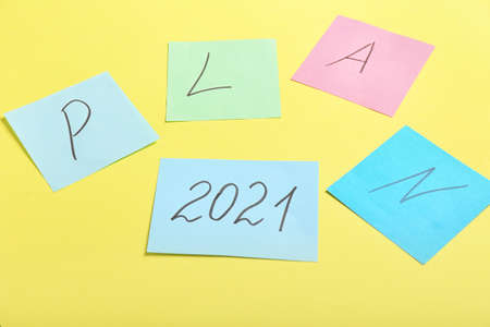 Paper sheets with word PLAN and figure 2021 on color backgroundの写真素材