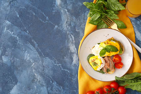 Tasty sandwiches with florentine eggs and bacon on color backgroundの写真素材