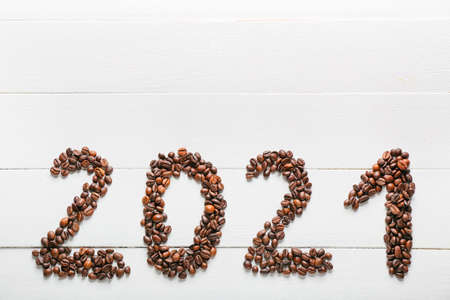 Figure 2021 made of coffee beans on white wooden backgroundの写真素材