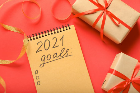 Notebook with text 2021 GOALS and Christmas gifts on color backgroundの写真素材