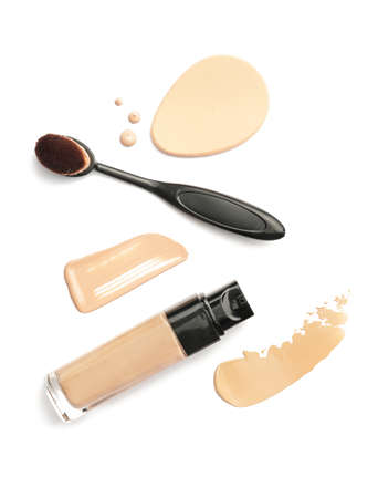 Bottle of makeup foundation, brush, sponge and samples on white background