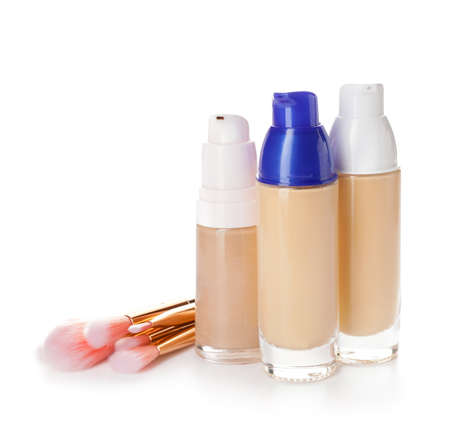 Bottles of makeup foundation and brushes on white backgroundの写真素材