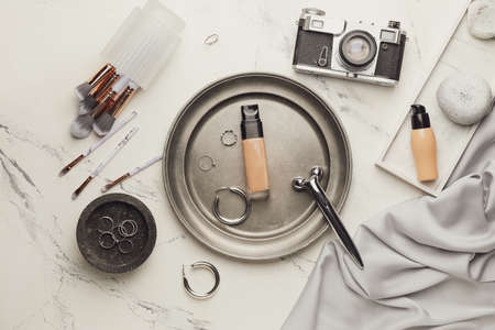 Bottles of makeup foundation, accessories and photo camera on light backgroundの写真素材