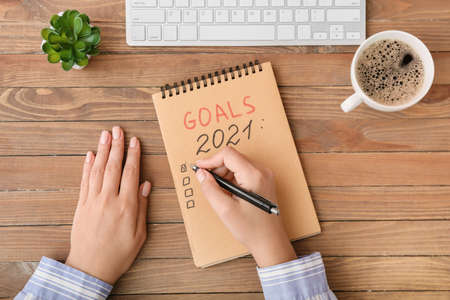 Woman making to-do list on 2021 year at table