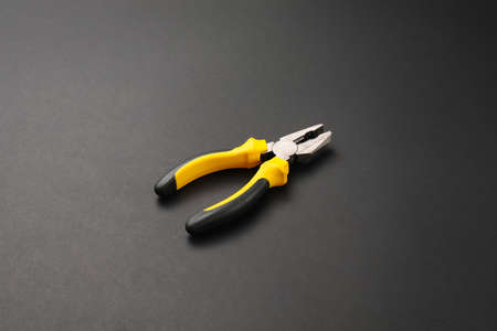 Builder's pliers on dark backgroundの写真素材