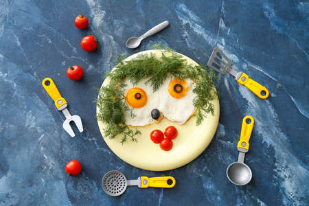 Creative breakfast for children with eggs and fresh vegetables on color backgroundの写真素材