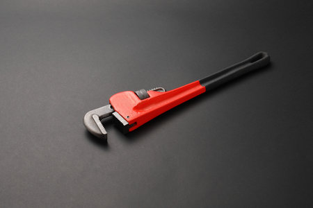 Plumbing wrench on dark background